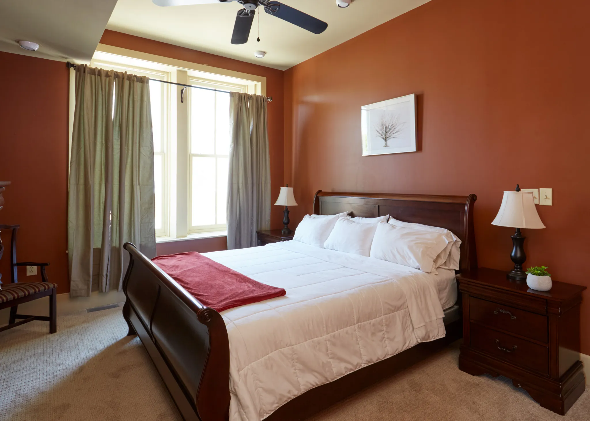 a bed with a fan in the corner