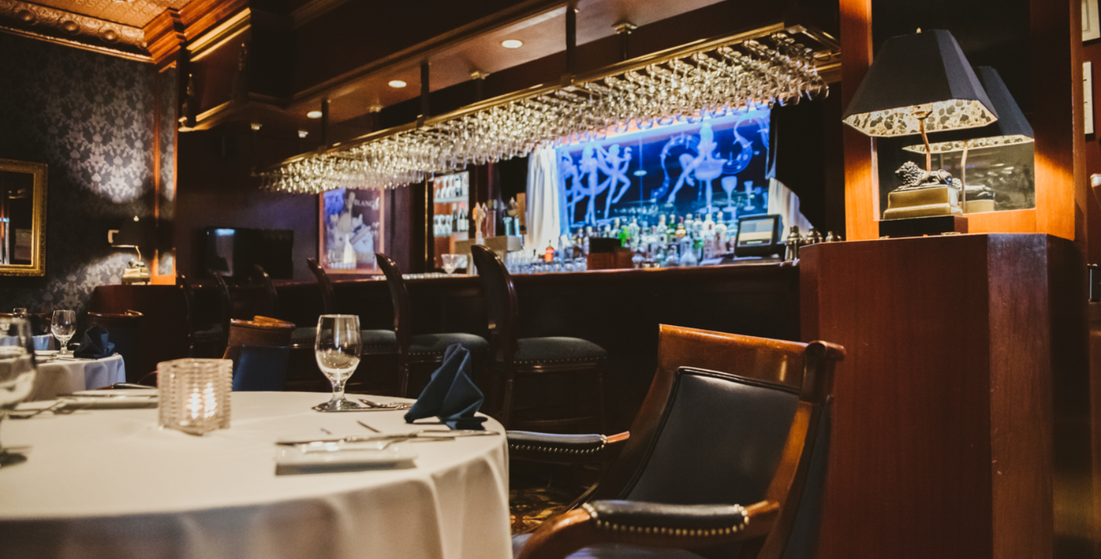 a table with a white tablecloth and chairs in a restaurant