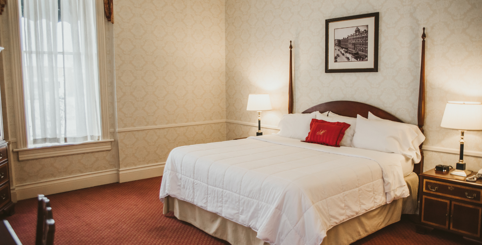 a bed with a lamp and a picture on the wall