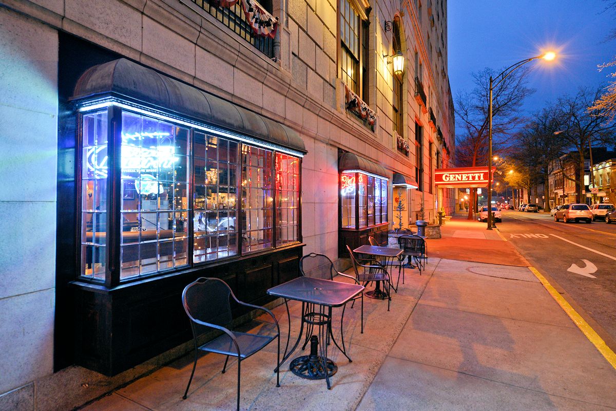 a sidewalk with tables and chairs on it