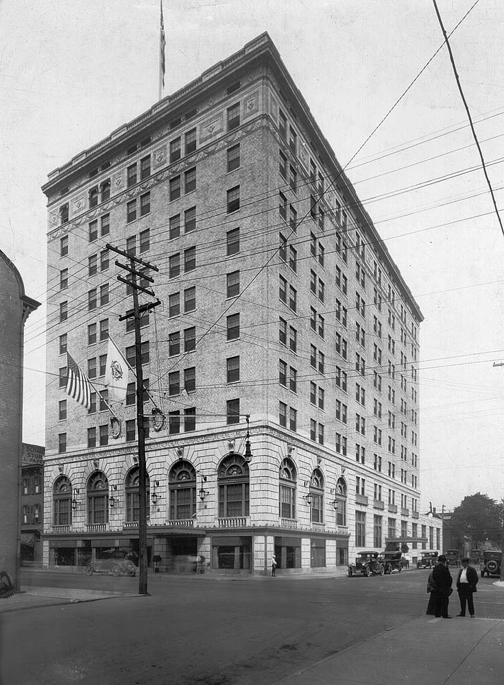a tall building with a flag on the corner