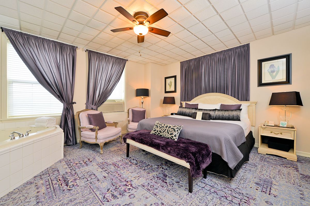 a bedroom with purple curtains and a bed
