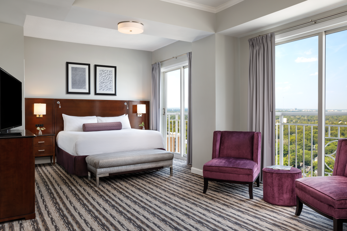 a bedroom with a bed and purple chairs