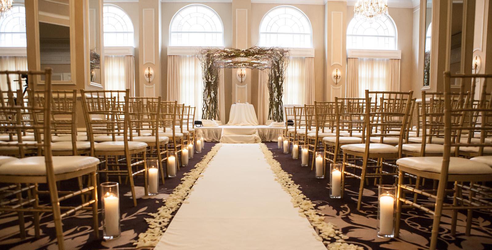 a wedding ceremony with chairs and candles