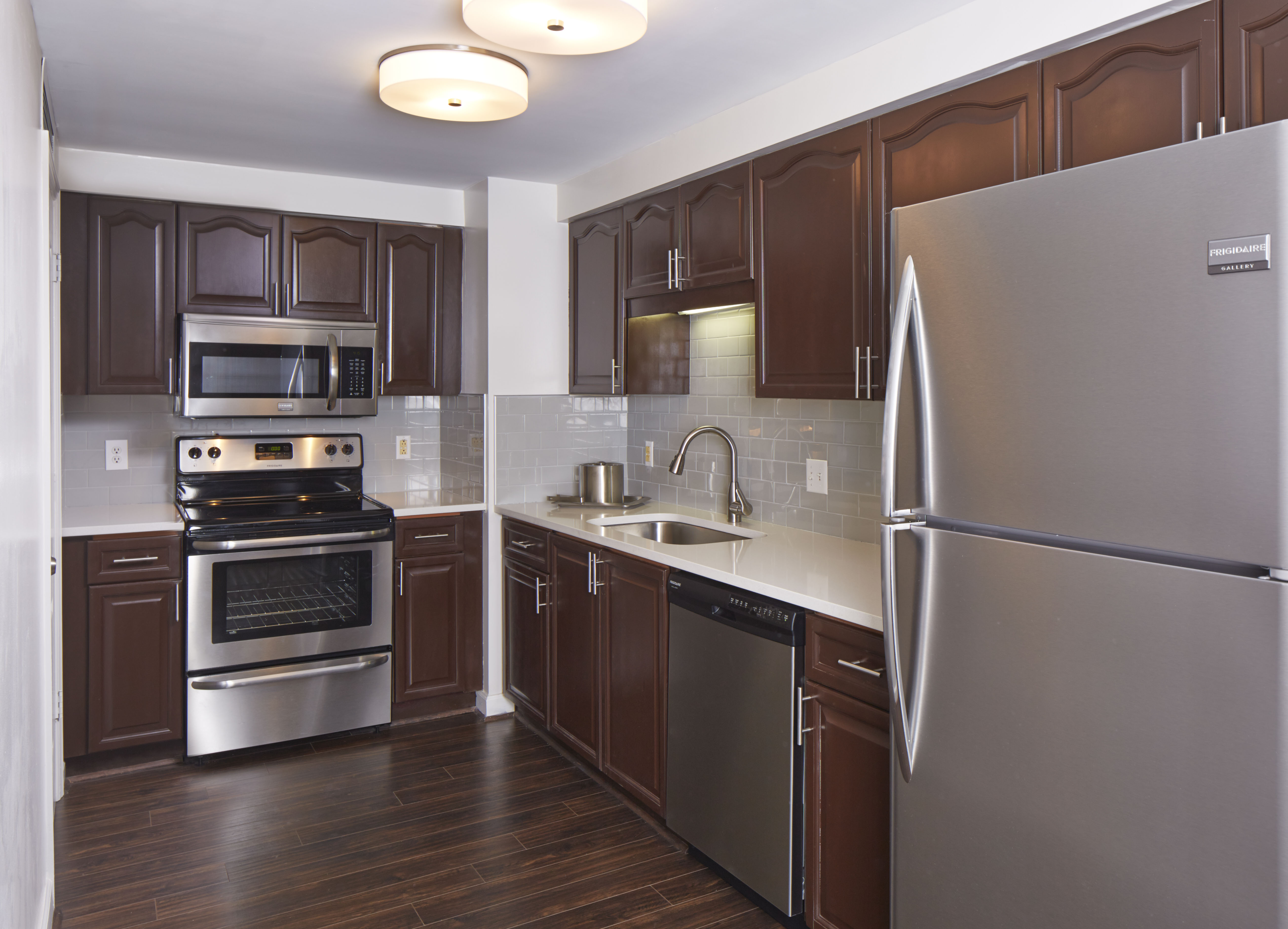 a kitchen with dark cabinets and stainless steel appliances