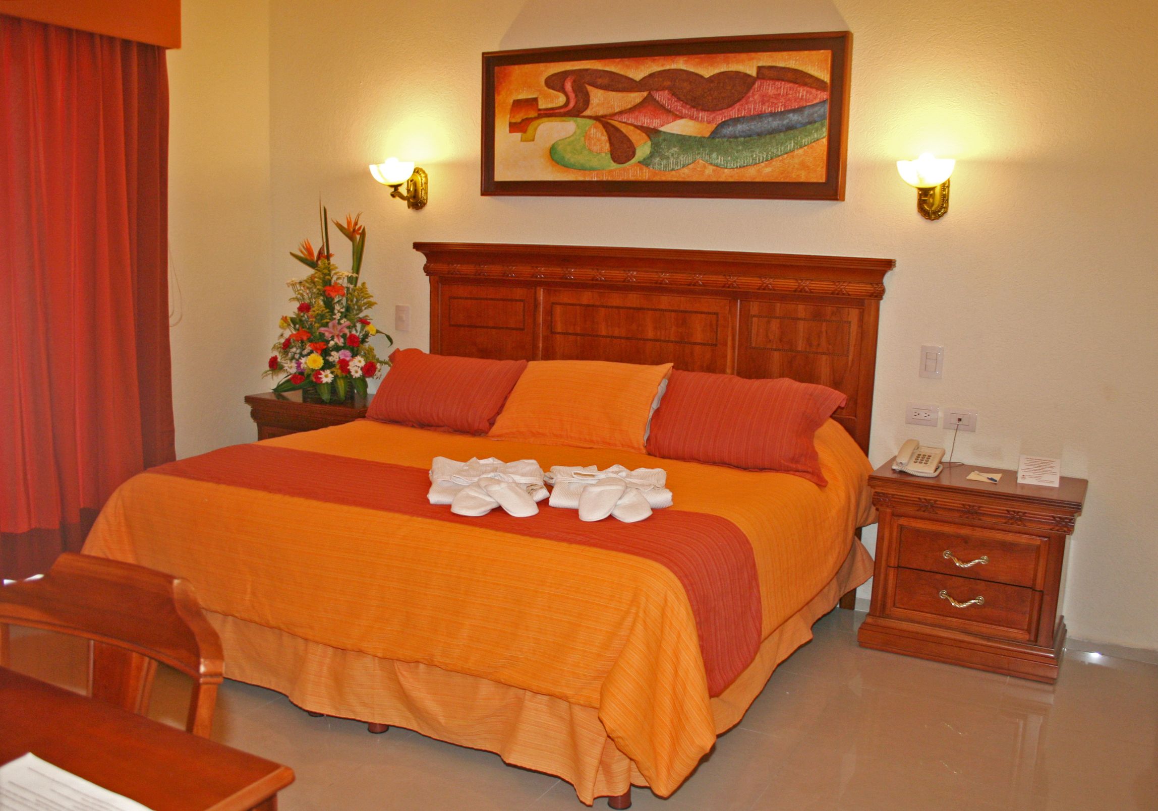 a bed with orange sheets and pillows