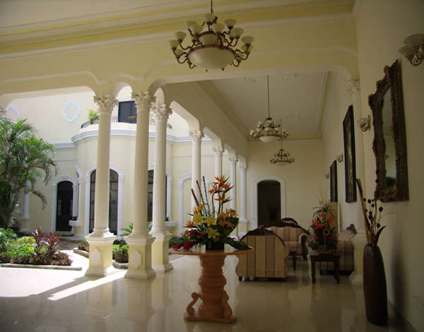 a large white hall with columns and a vase of flowers