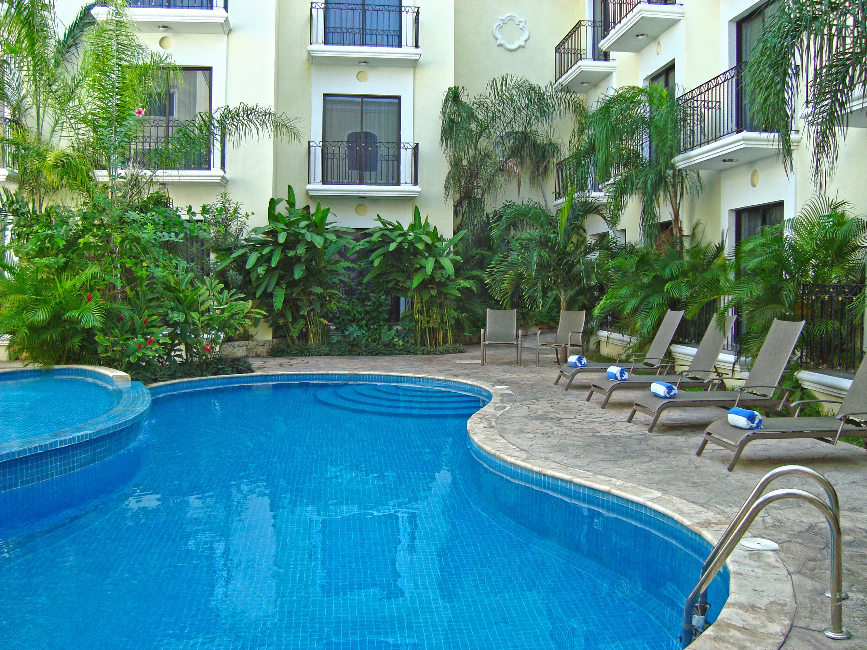 a pool with lounge chairs and a building