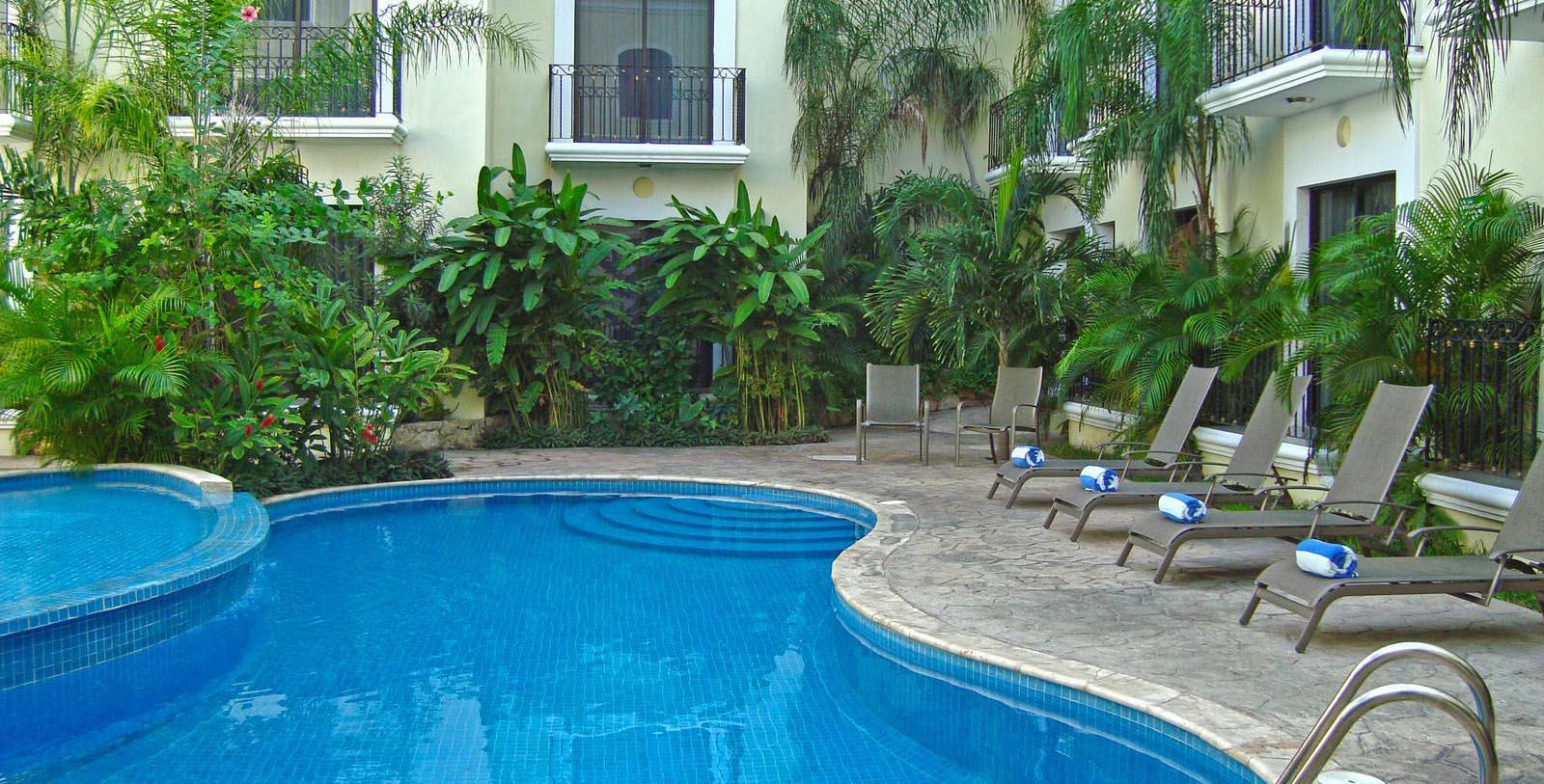 a swimming pool with lounge chairs and a building