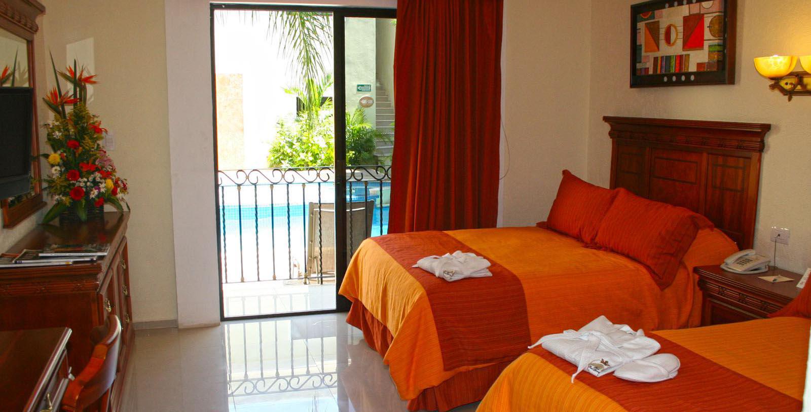 a bed with orange sheets and towels in a room with a pool