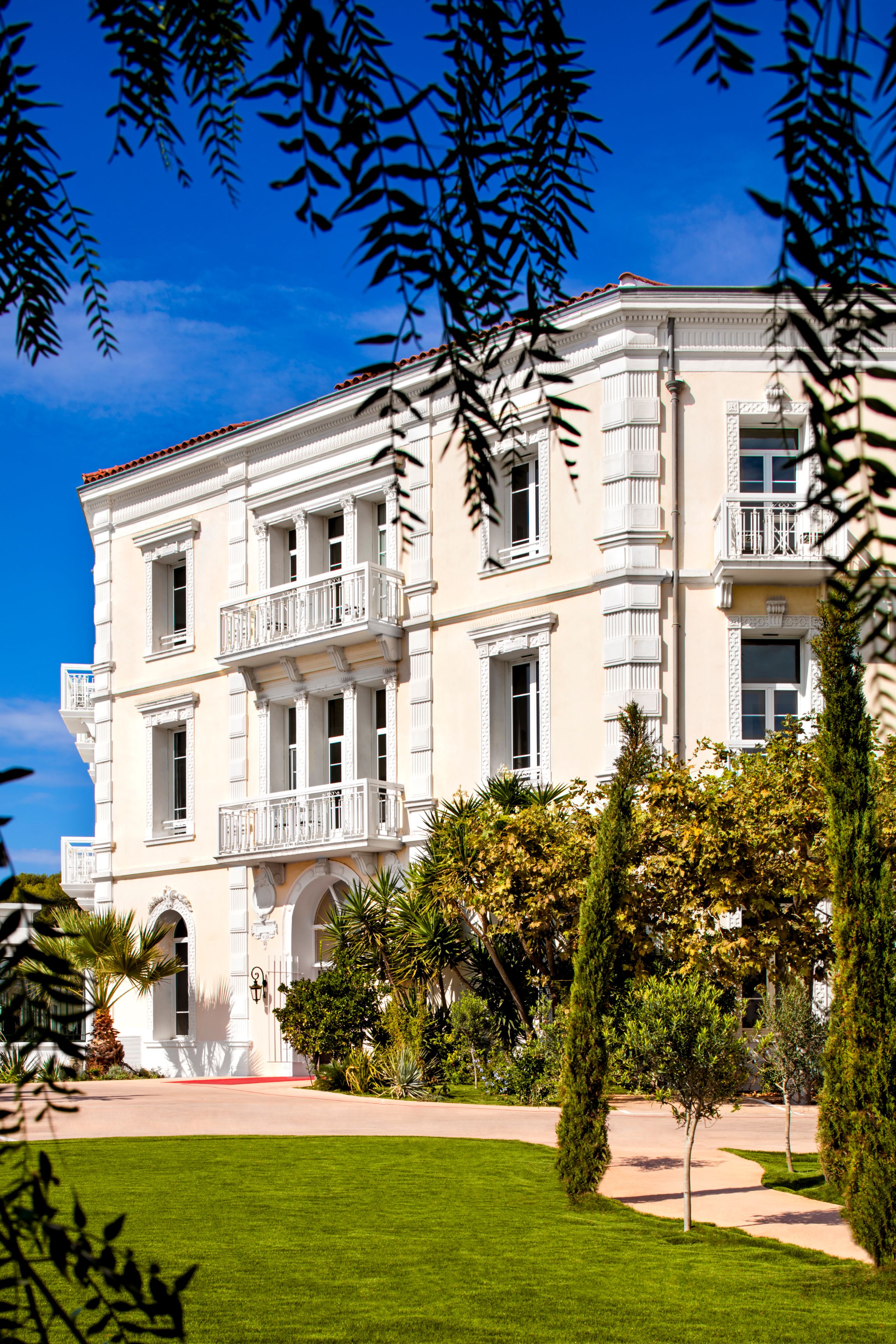 a white building with trees and bushes