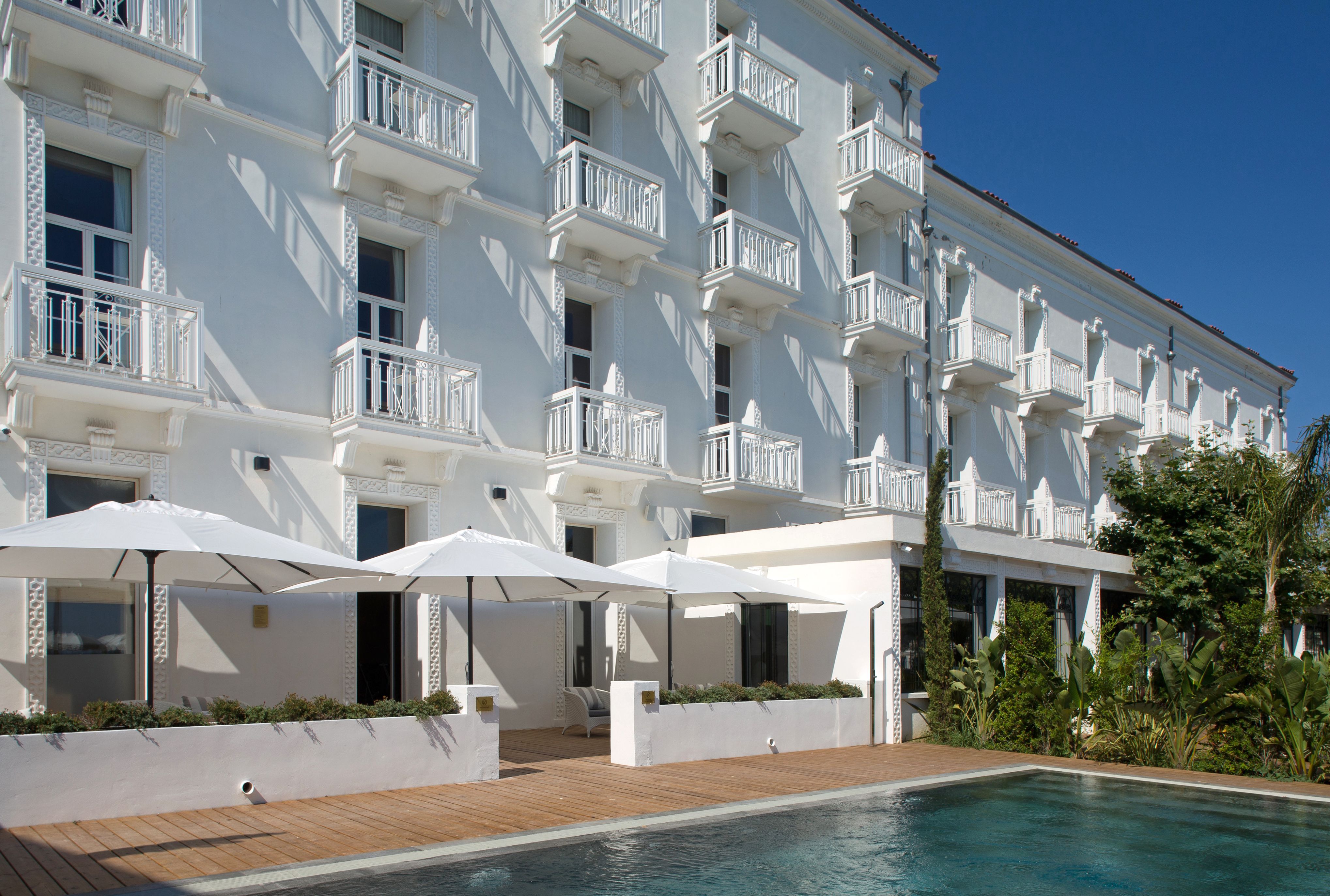 a building with a pool and umbrellas