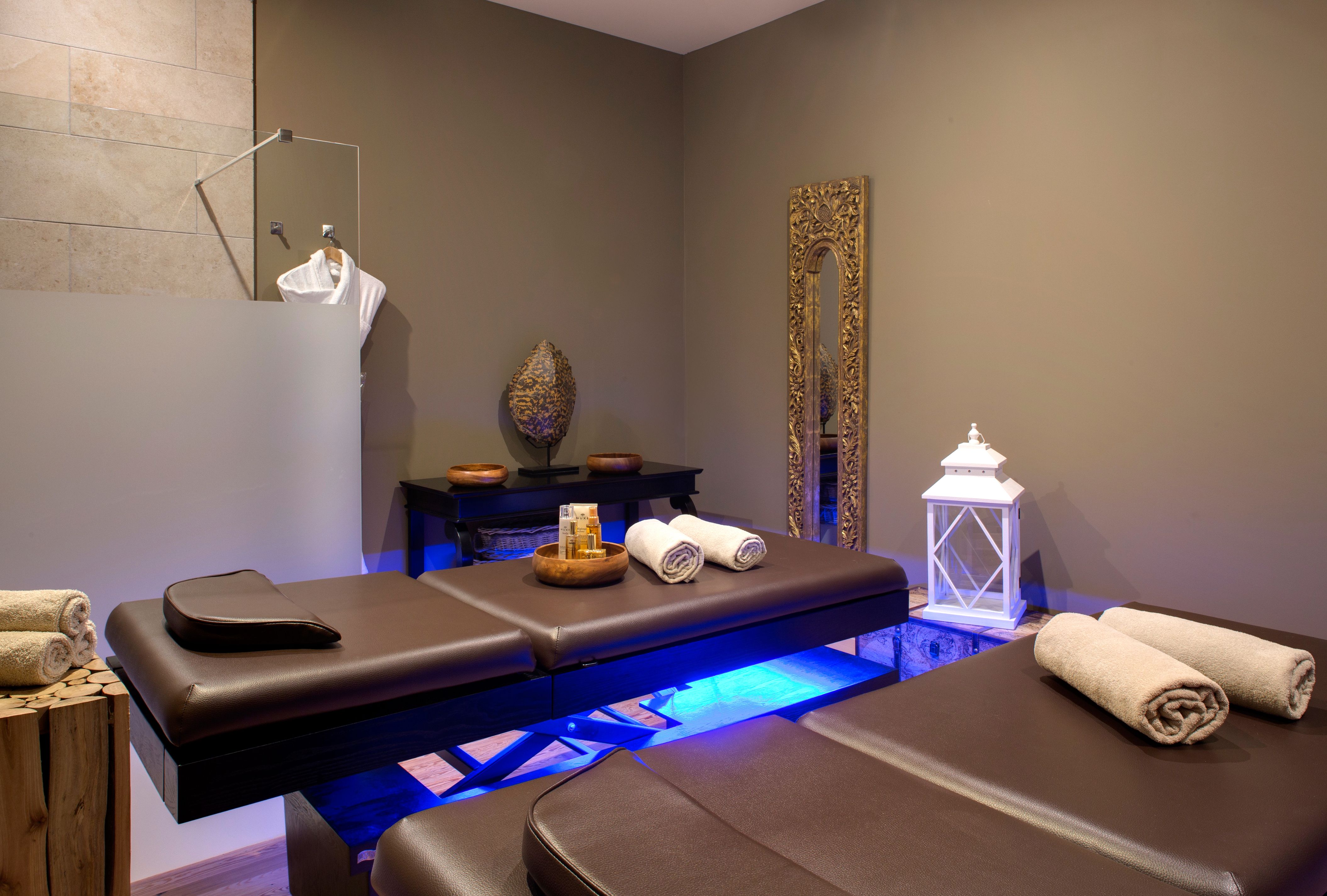 a massage room with brown leather benches and a mirror