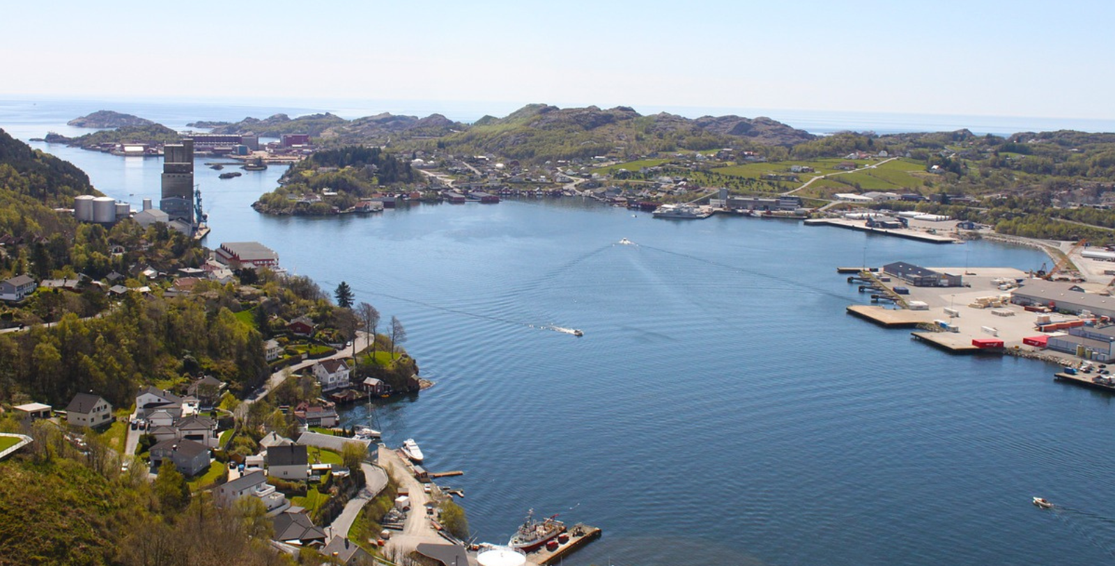 a body of water with houses and hills