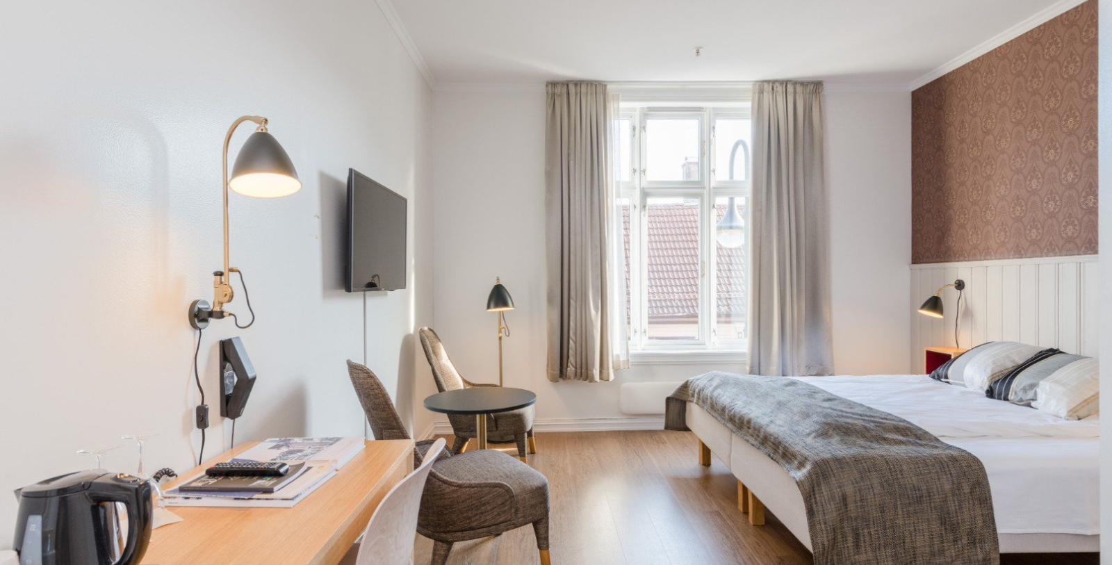 a room with a bed and a table and chairs