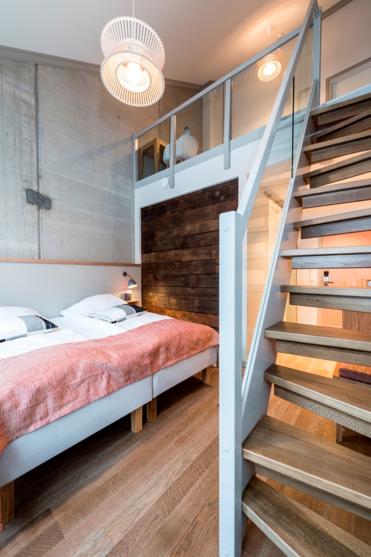 a bedroom with a wood staircase and a bed
