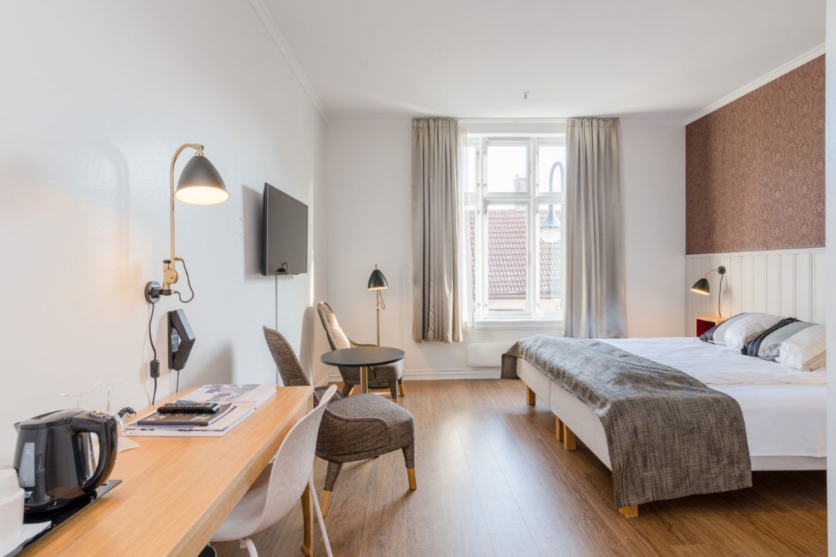 a room with a bed and a table and chairs