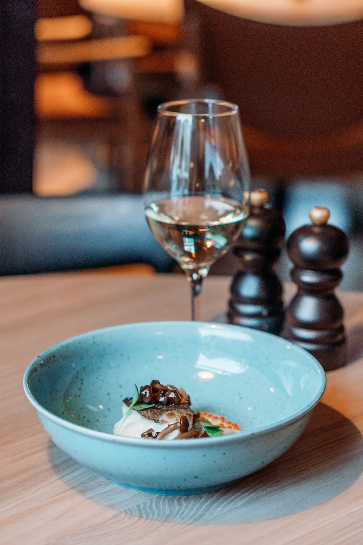 a glass of wine next to a bowl of food