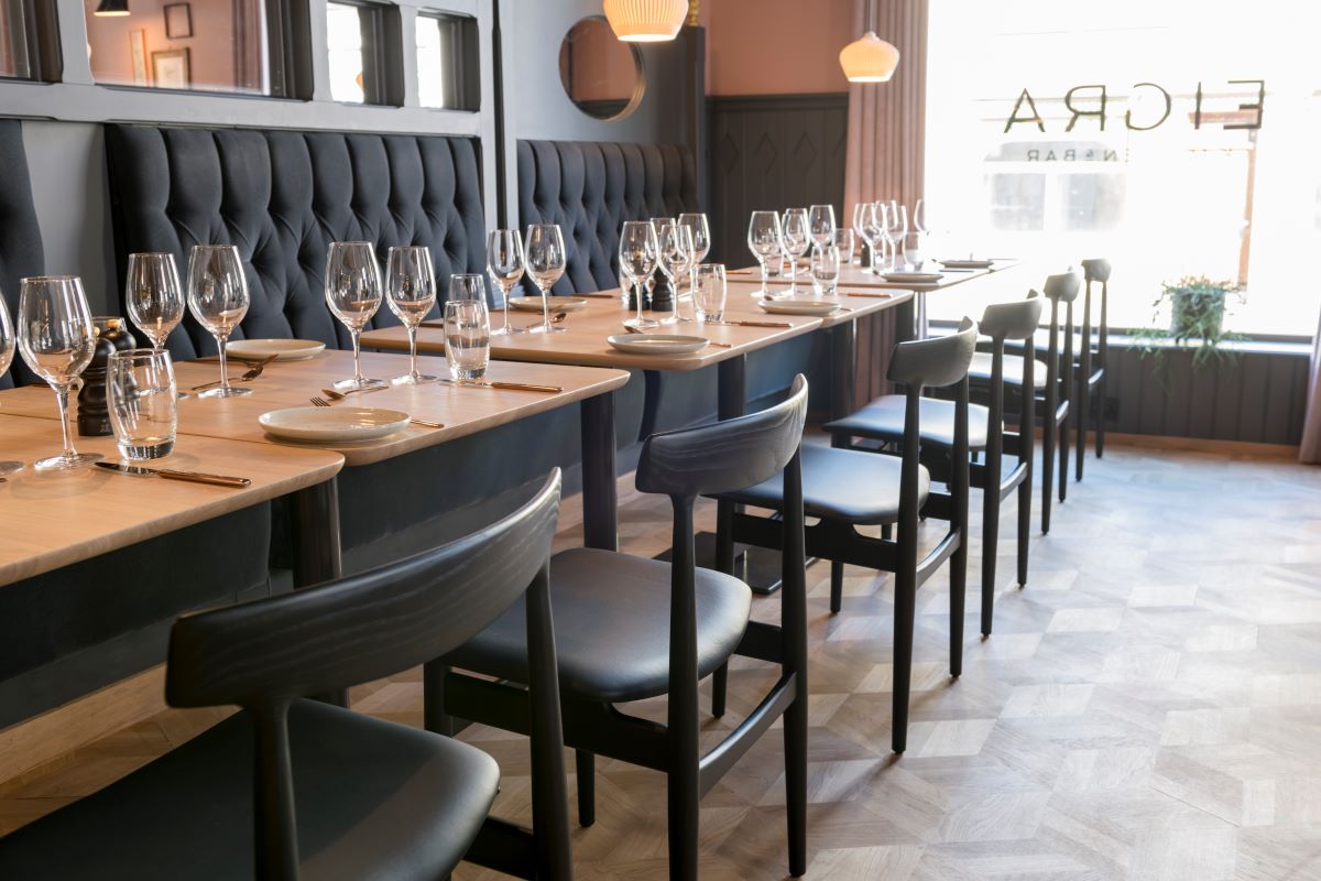 a long table with empty wine glasses and chairs
