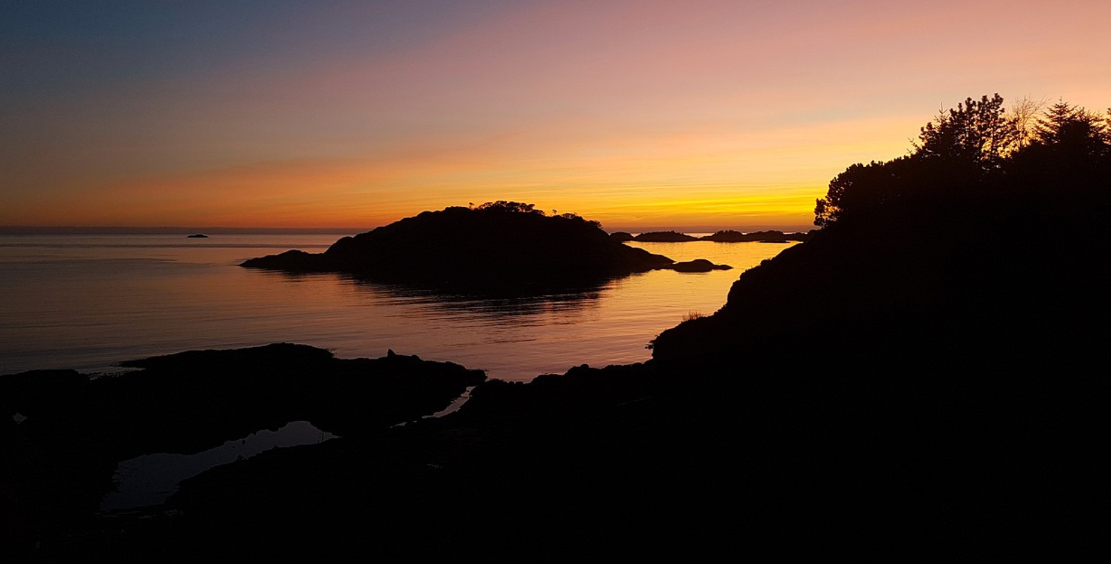 a sunset over water and land
