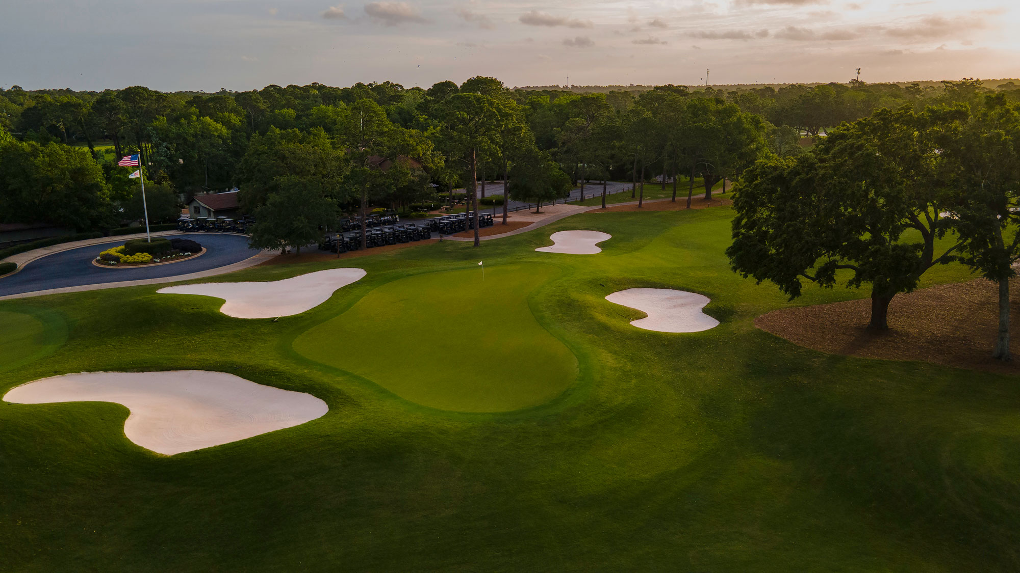 a golf course with sand bunkers and trees