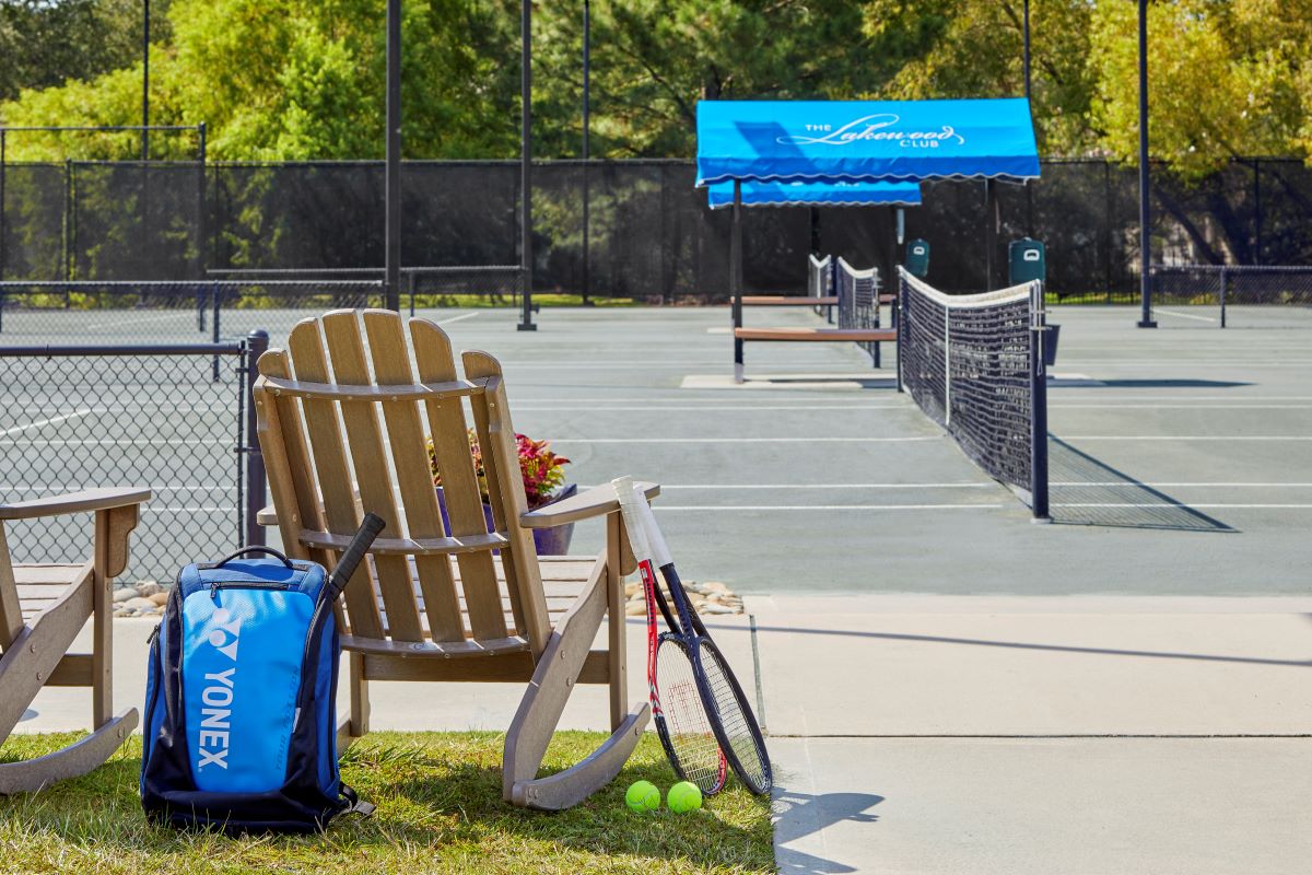 a tennis court with a chair and rackets