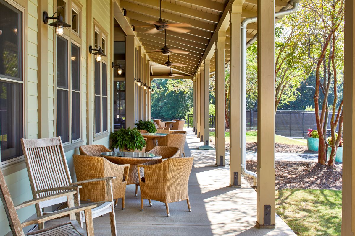 a porch with chairs and tables