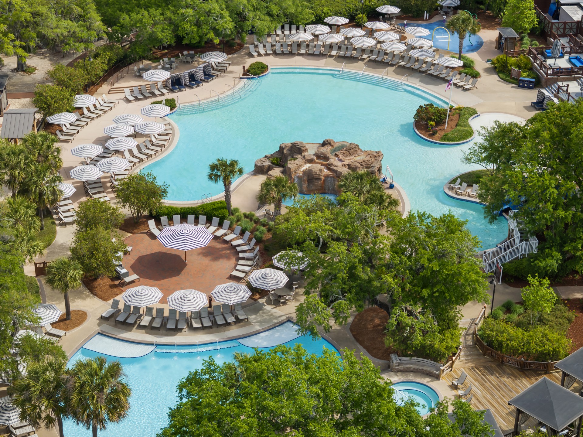 a swimming pool with chairs and umbrellas