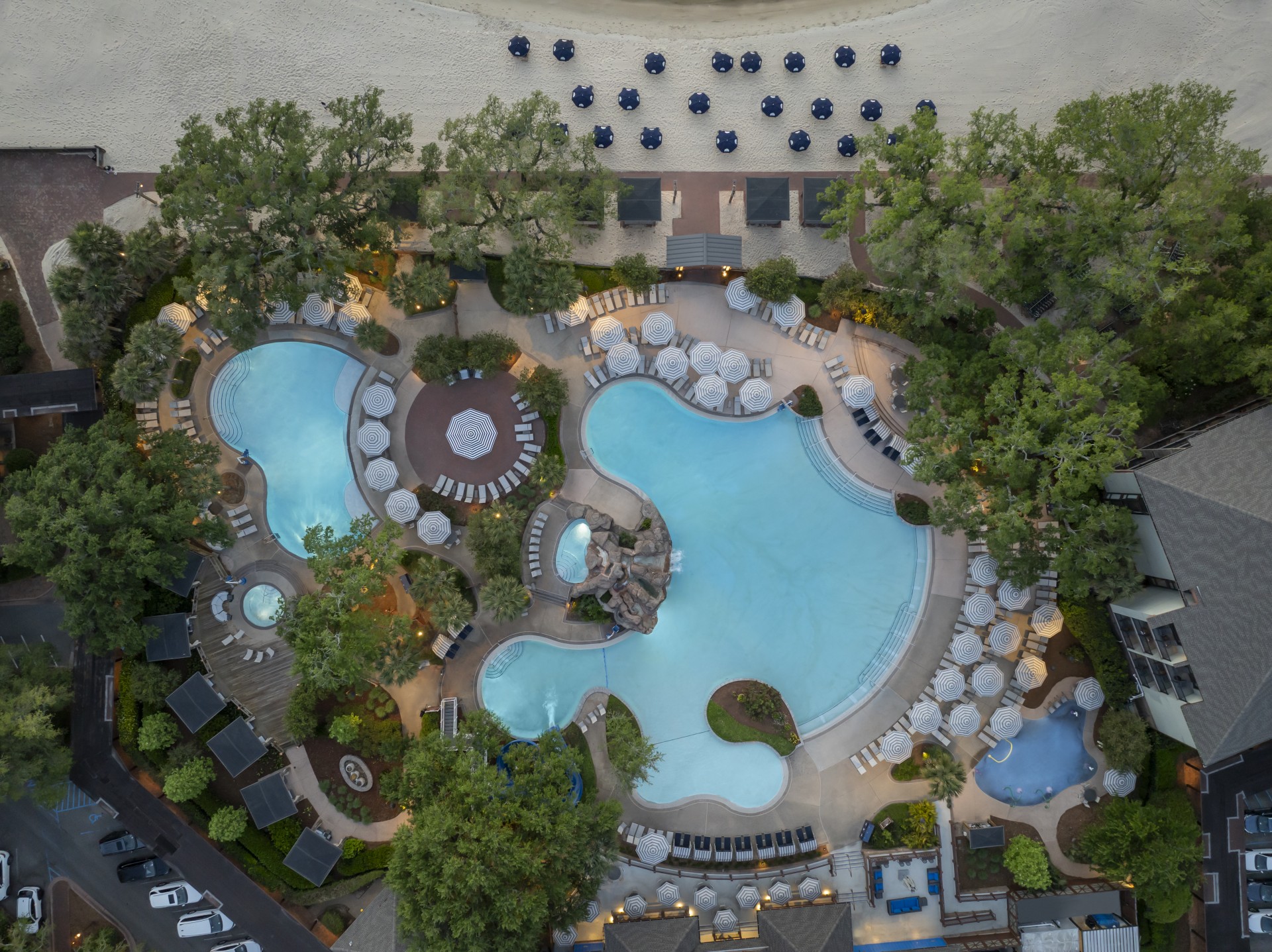 an aerial view of a resort with a pool and trees