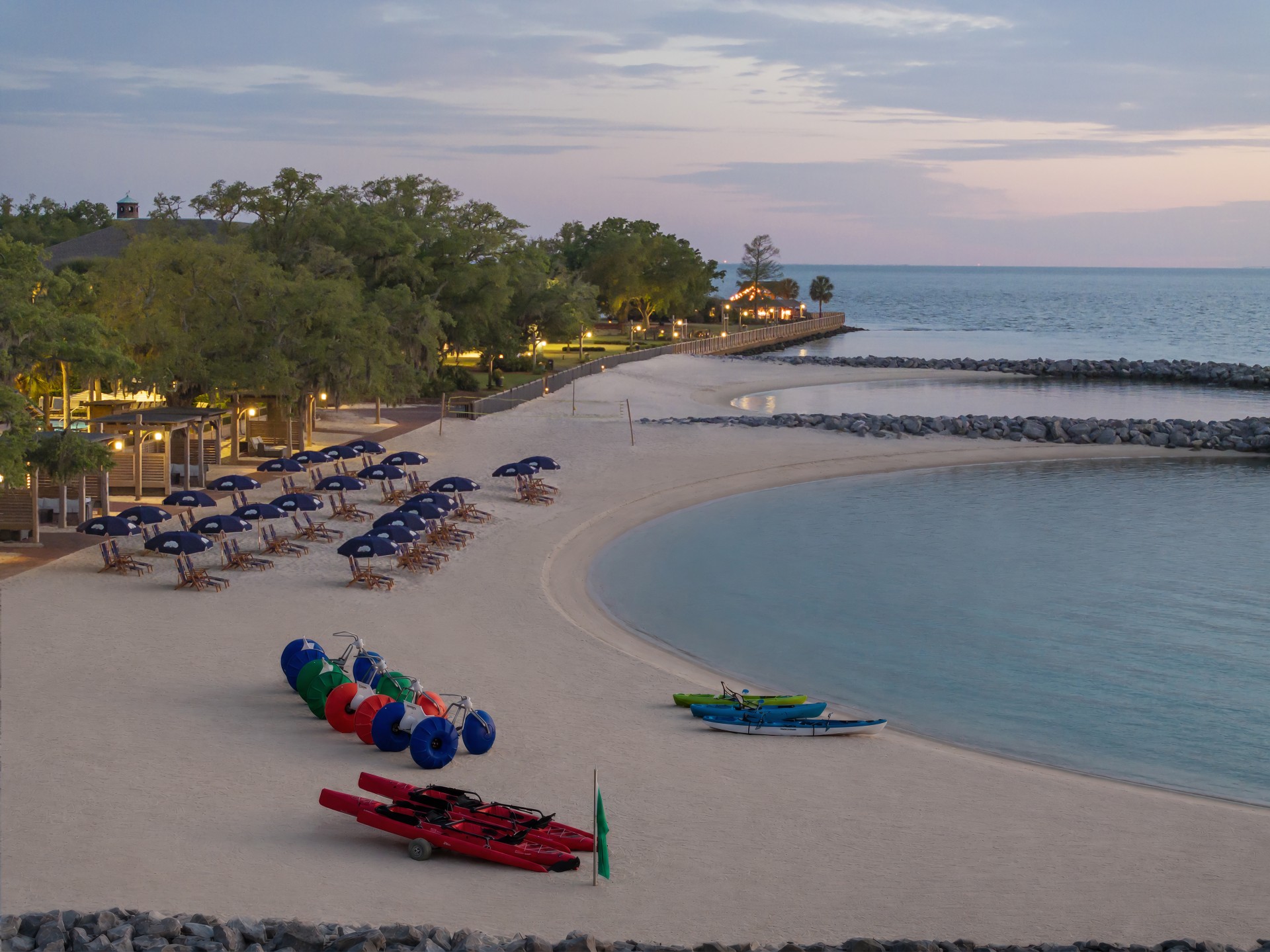 a beach with chairs and umbrellas and boats