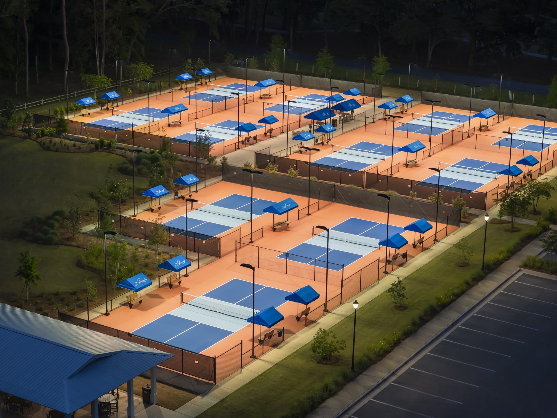 tennis courts with blue tents and trees