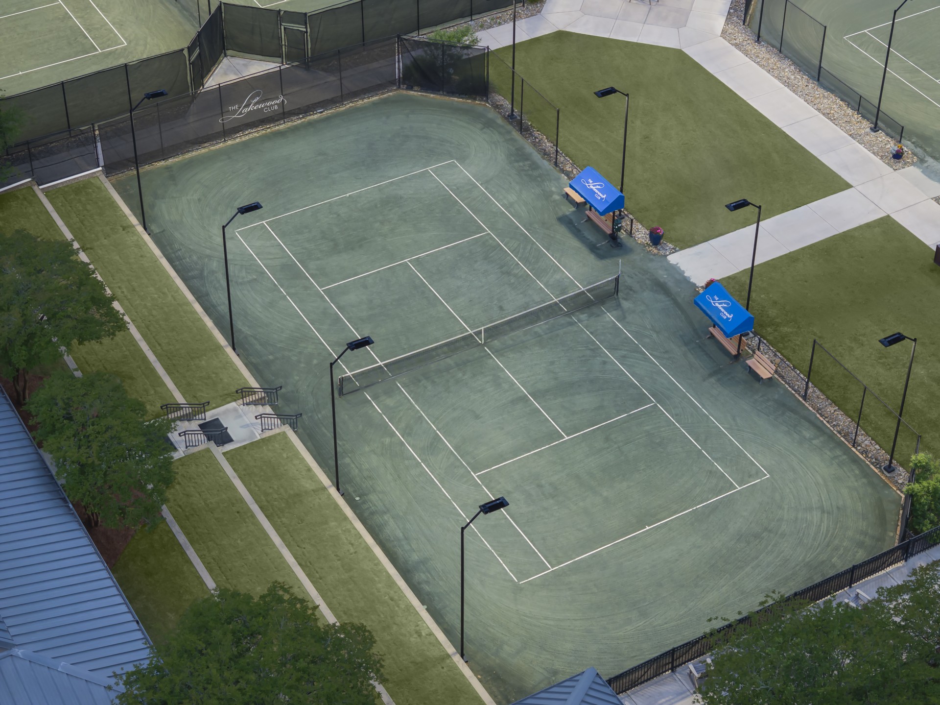 a tennis court with a fence and trees
