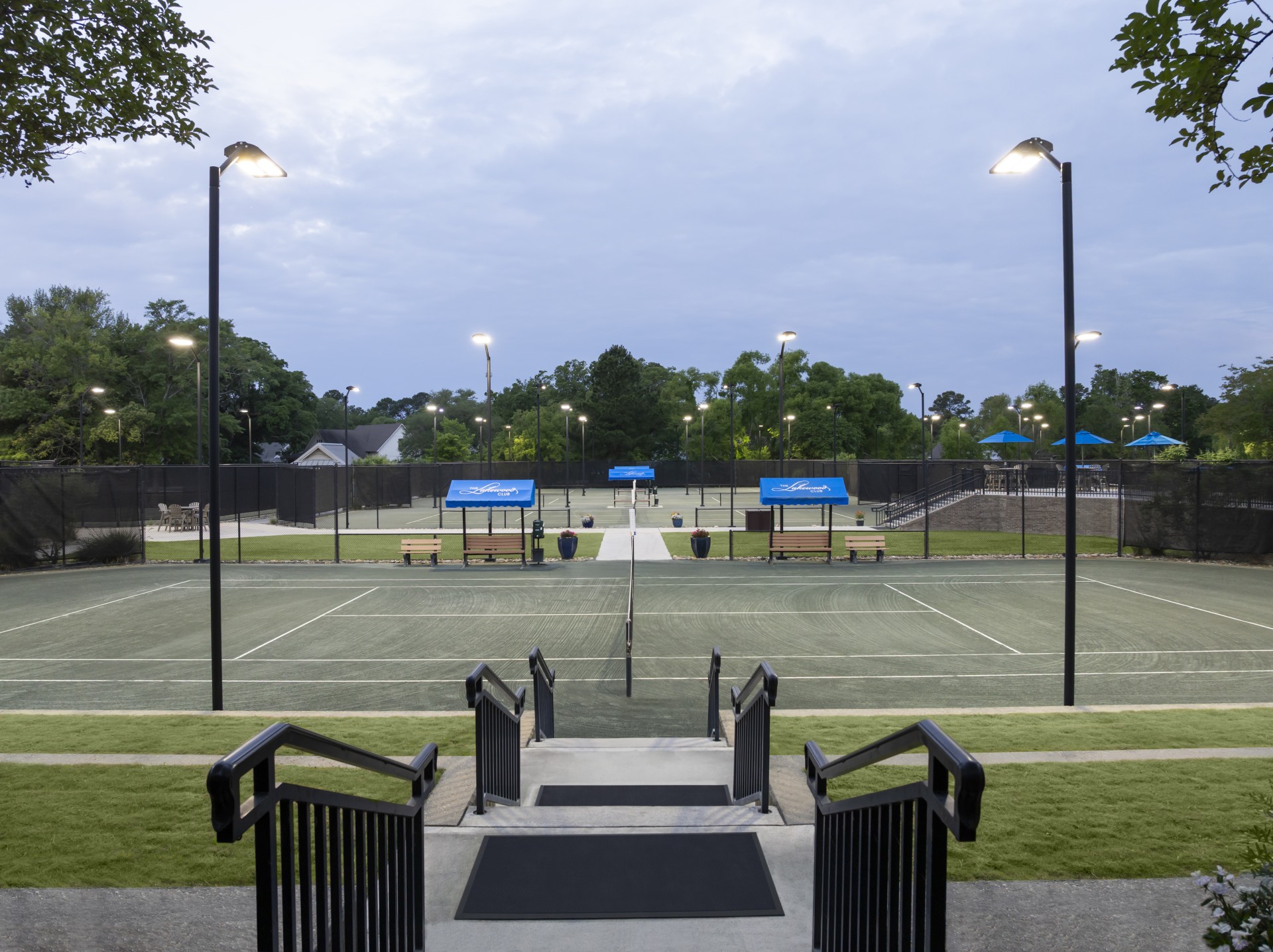 a tennis court with a fence and stairs