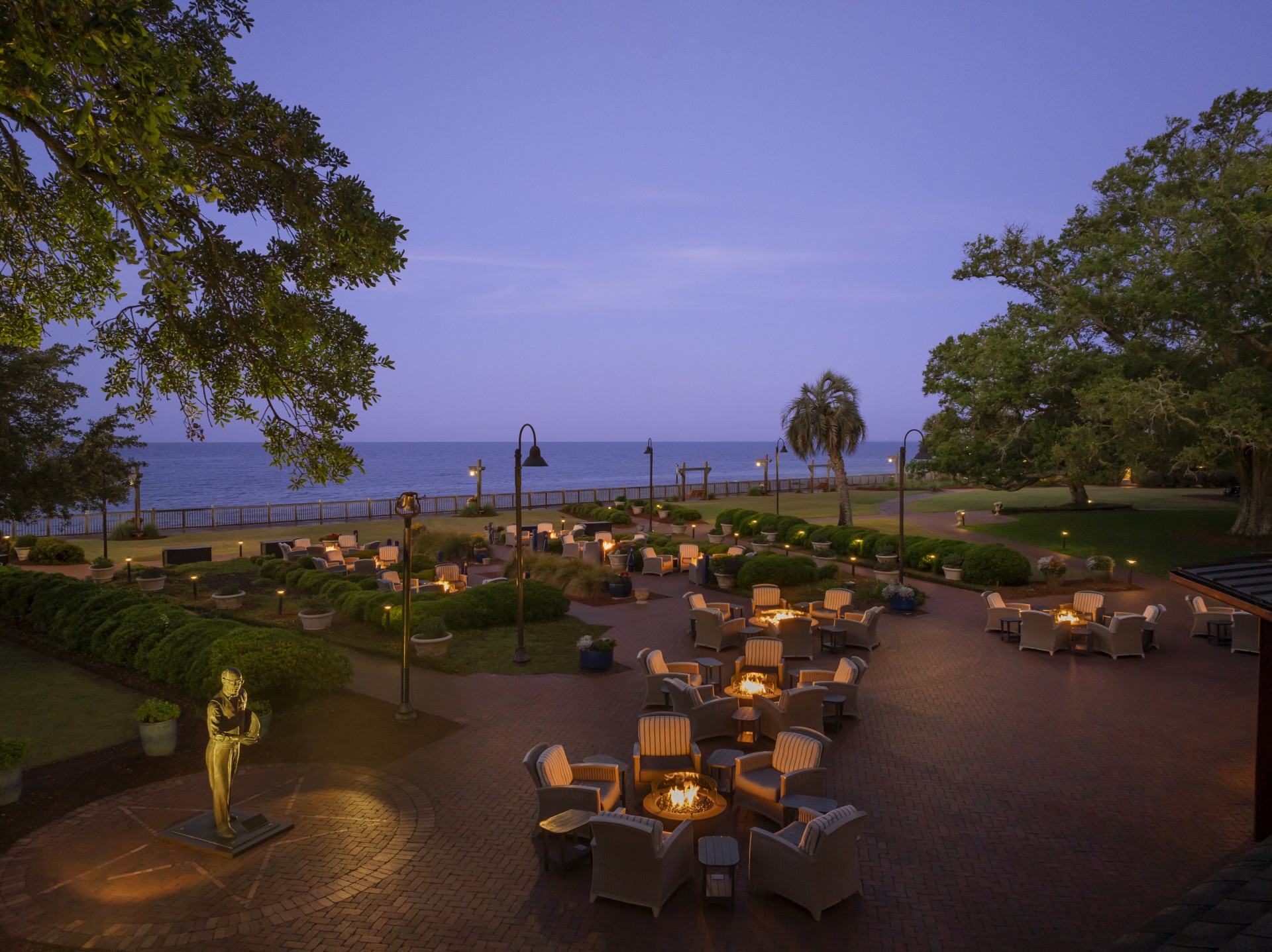 a patio area with chairs and a statue on the side