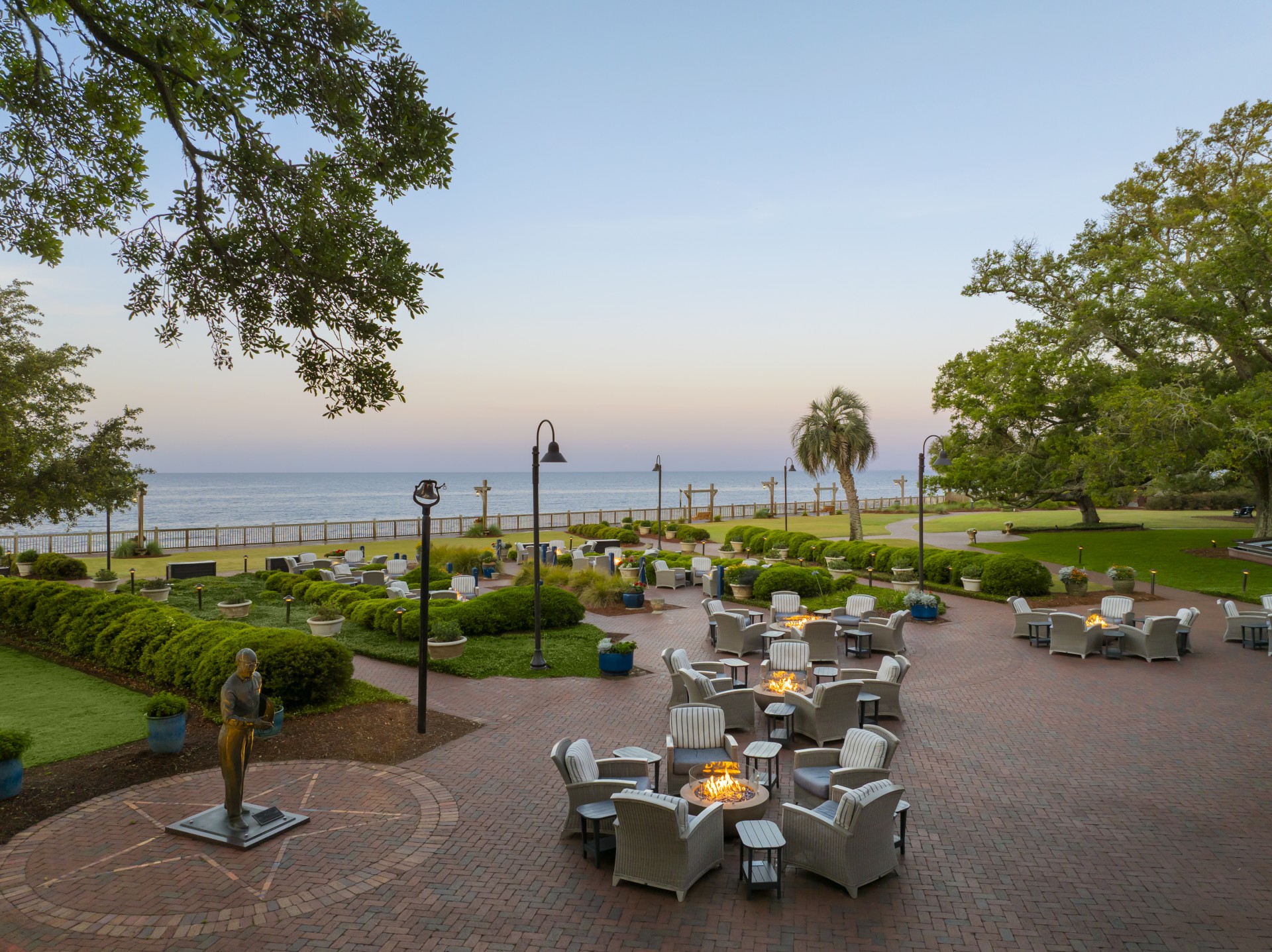 a patio area with chairs and tables and a statue on the side