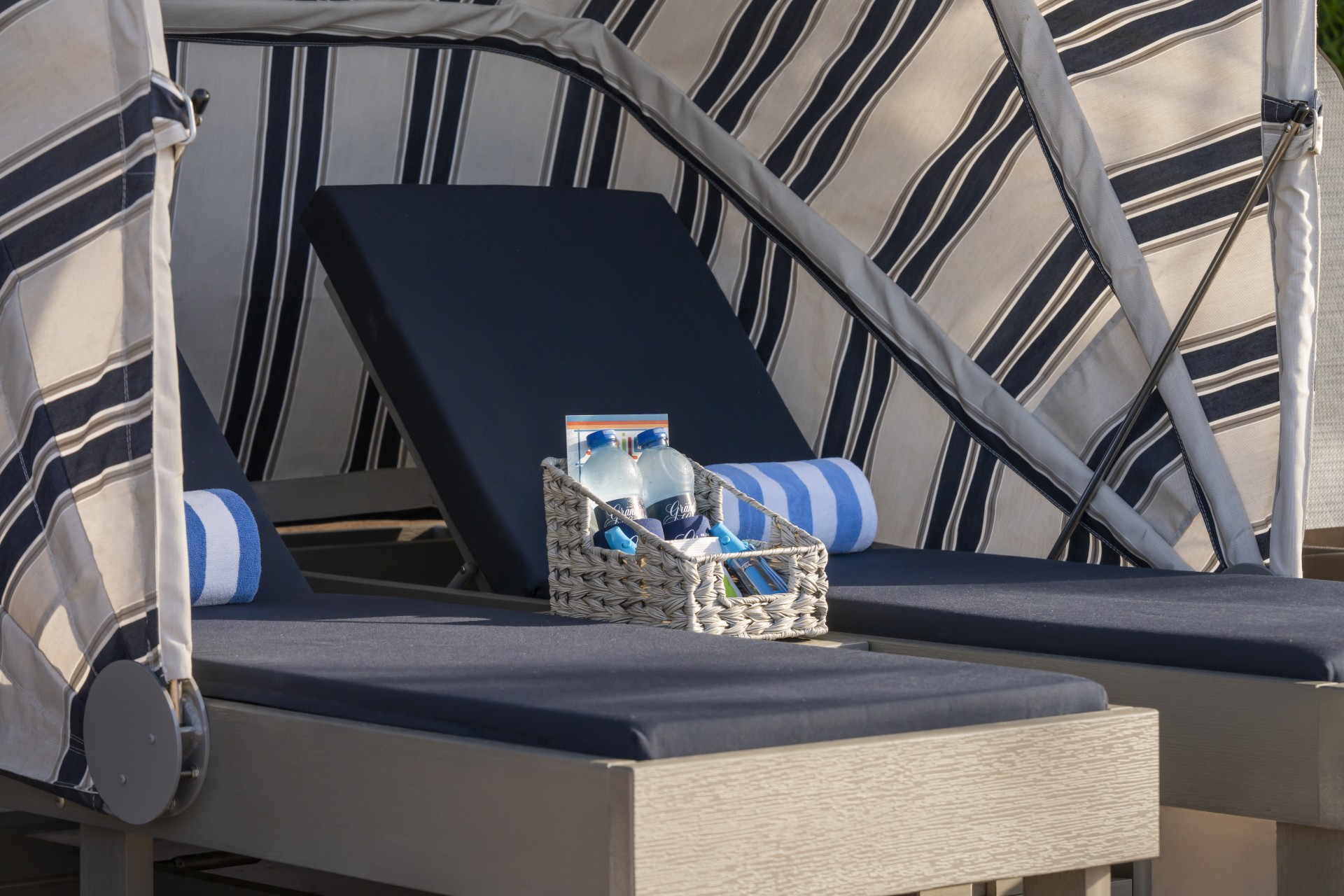 a basket of water and a basket of beach items on a chair