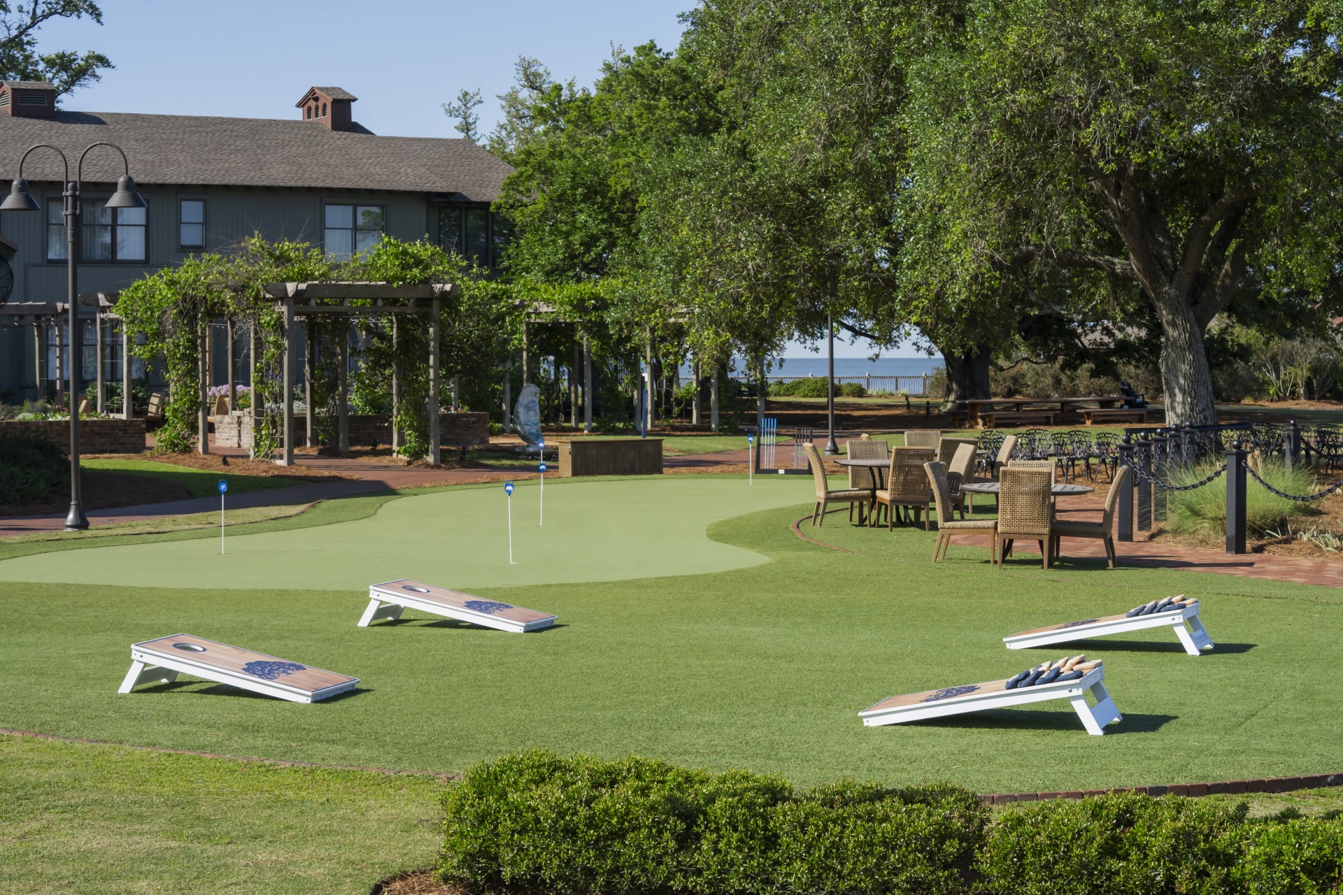 a golf course with a green putting green and chairs