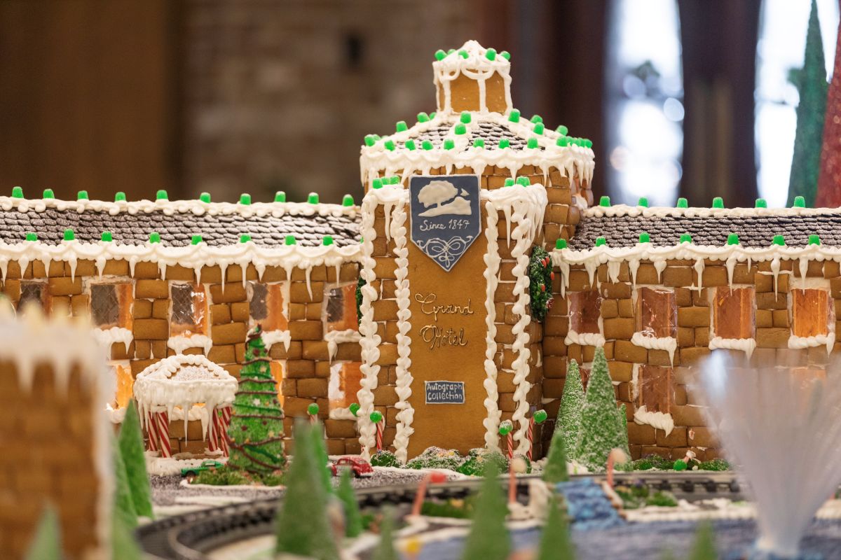 a gingerbread house with trees and train tracks