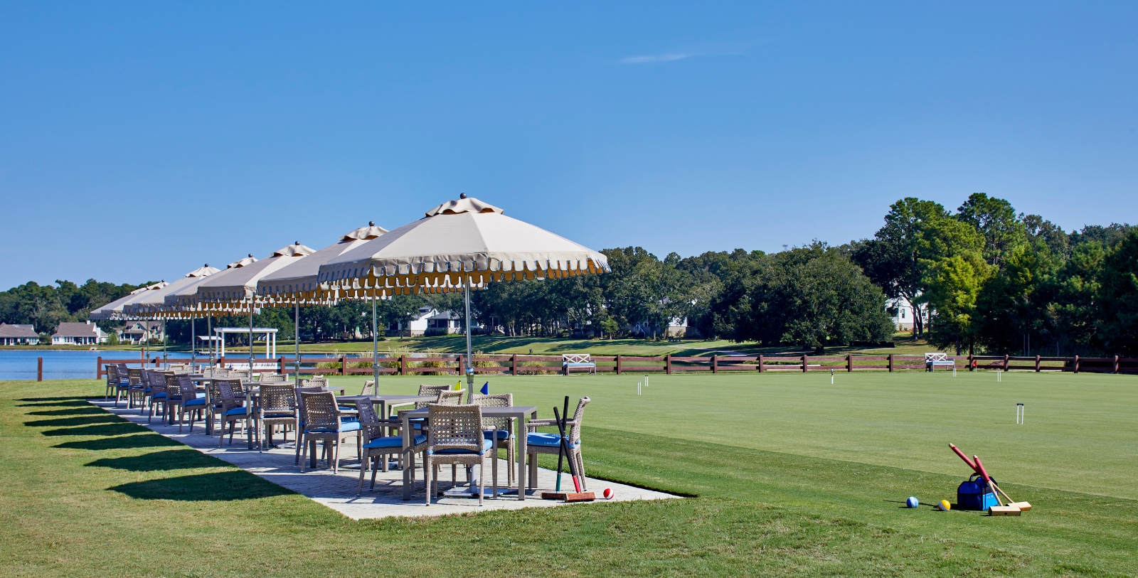 a table and chairs on a lawn with umbrellas