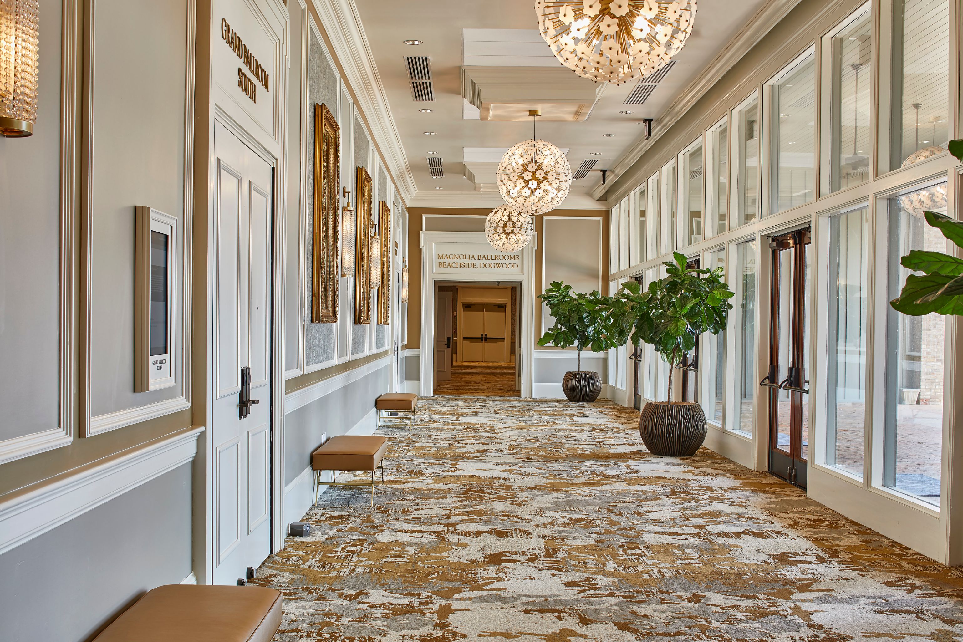 a hallway with a carpeted floor and chandeliers