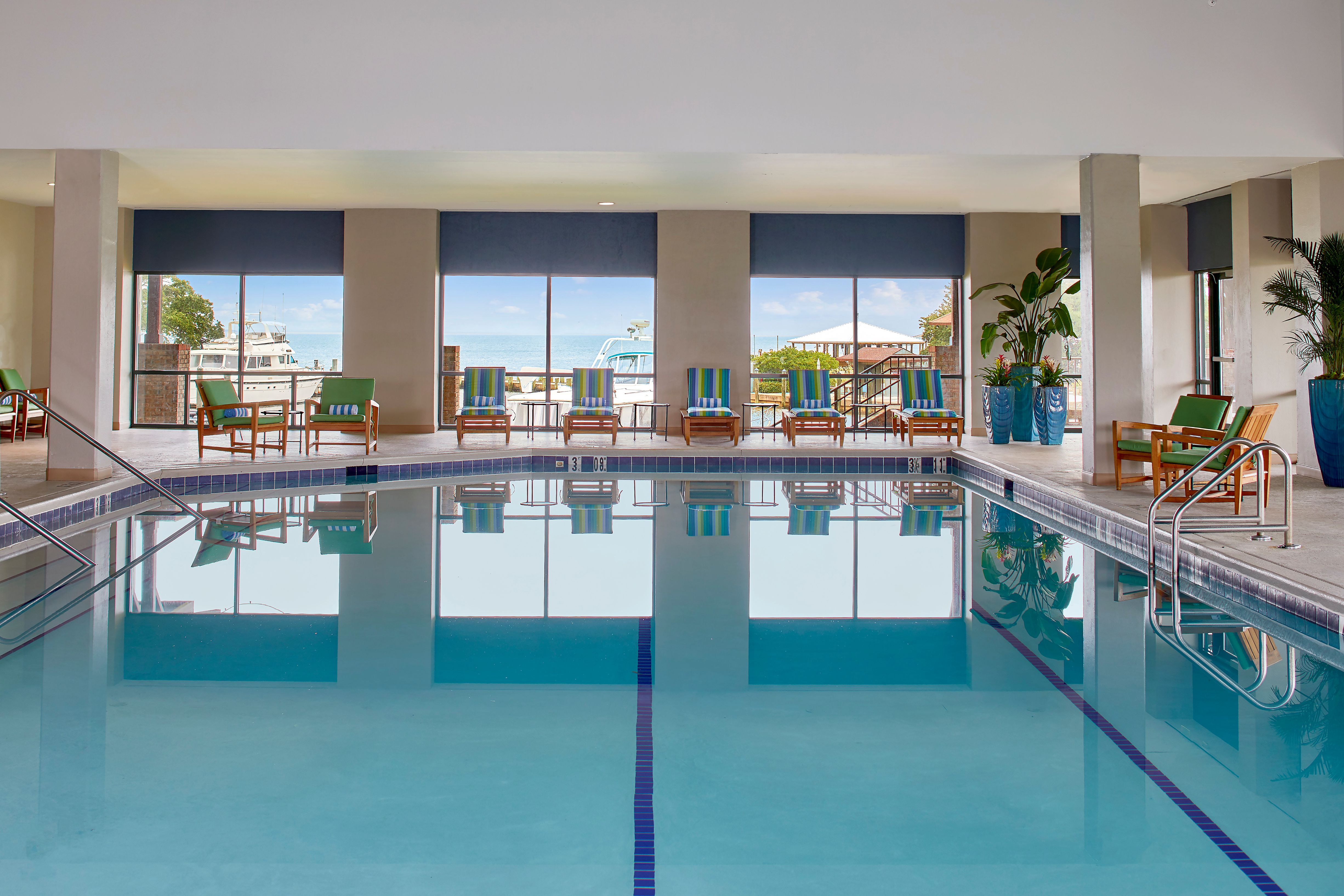 a swimming pool with chairs and a view of the ocean