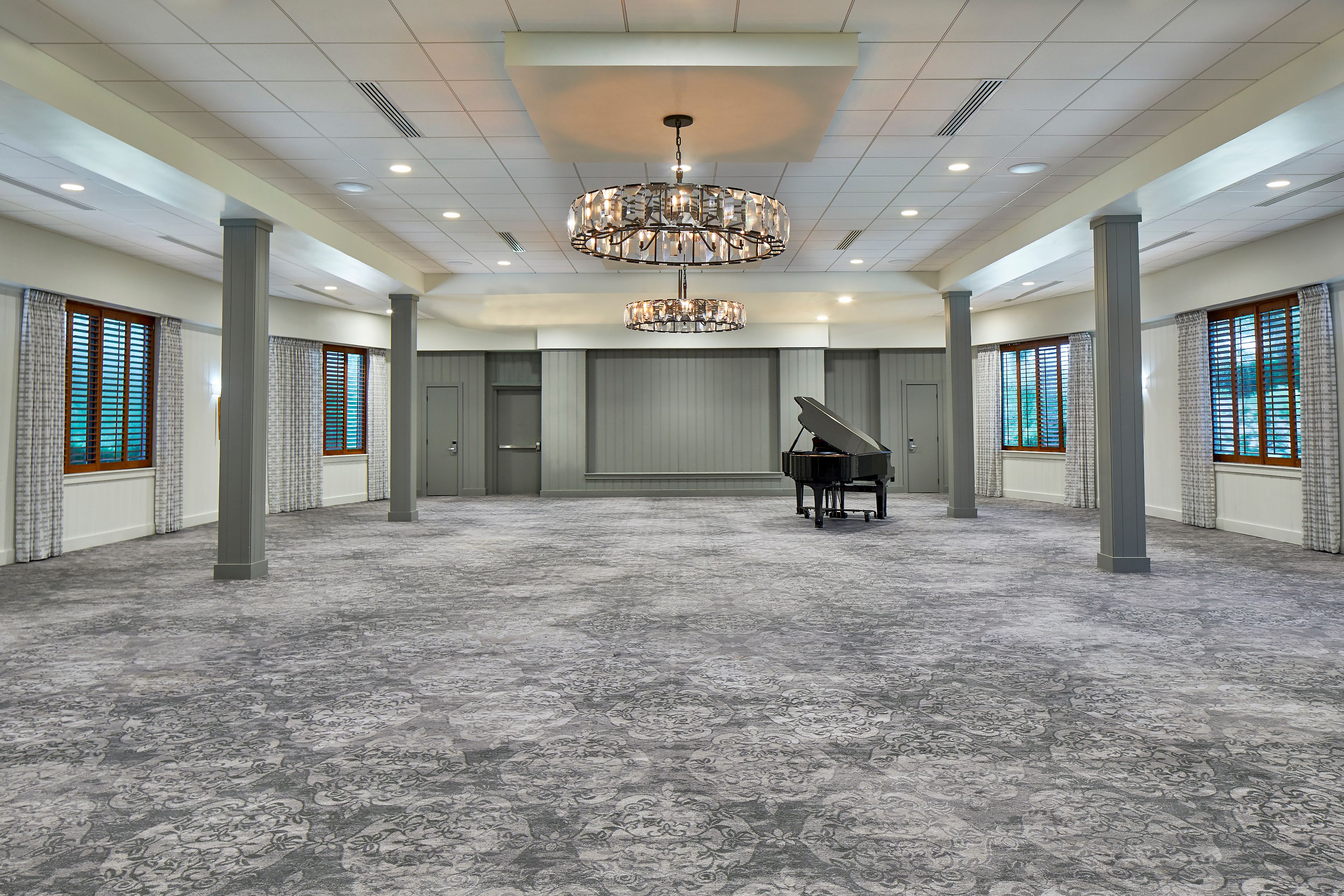 a room with a piano and chandelier