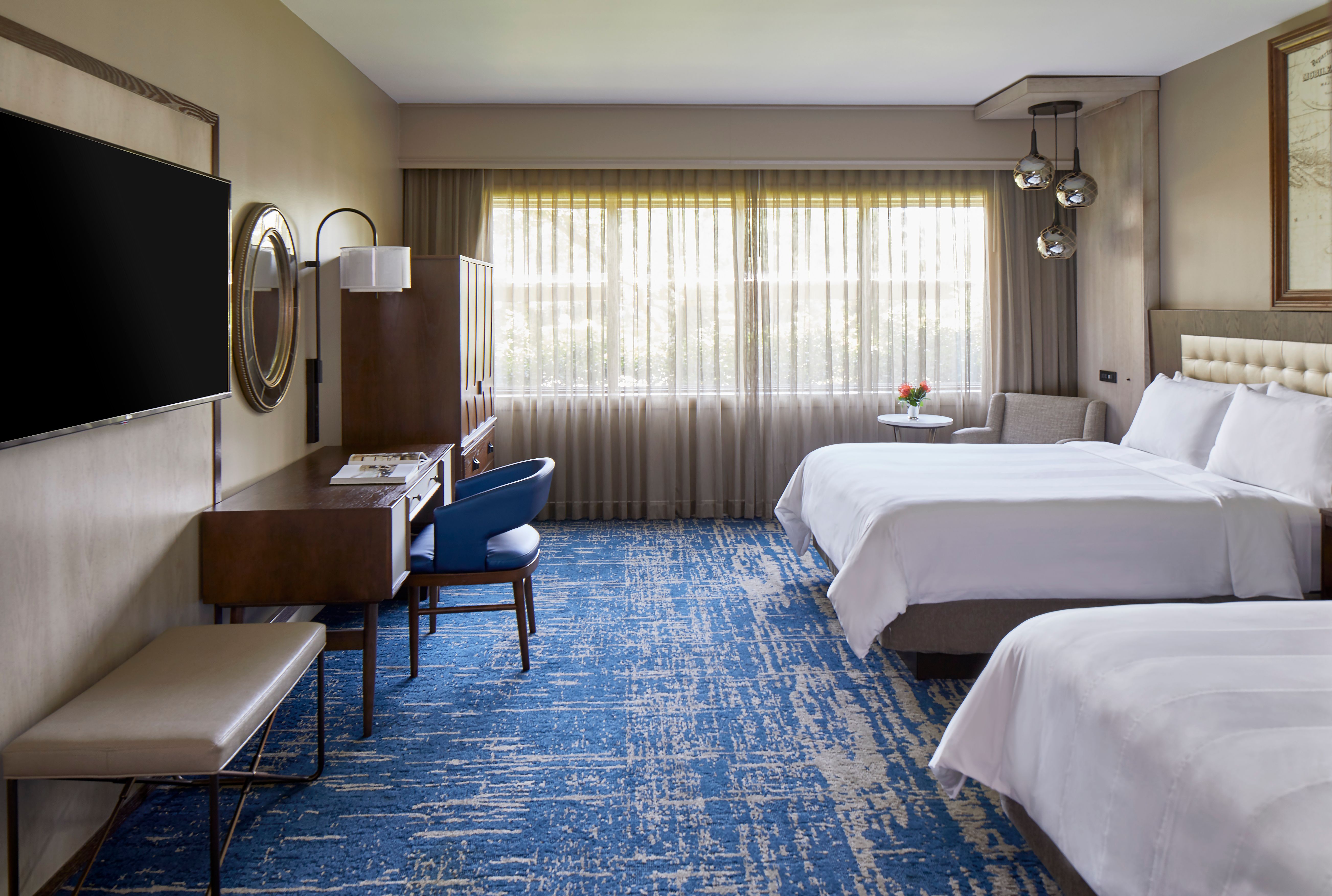 a room with two beds and a desk