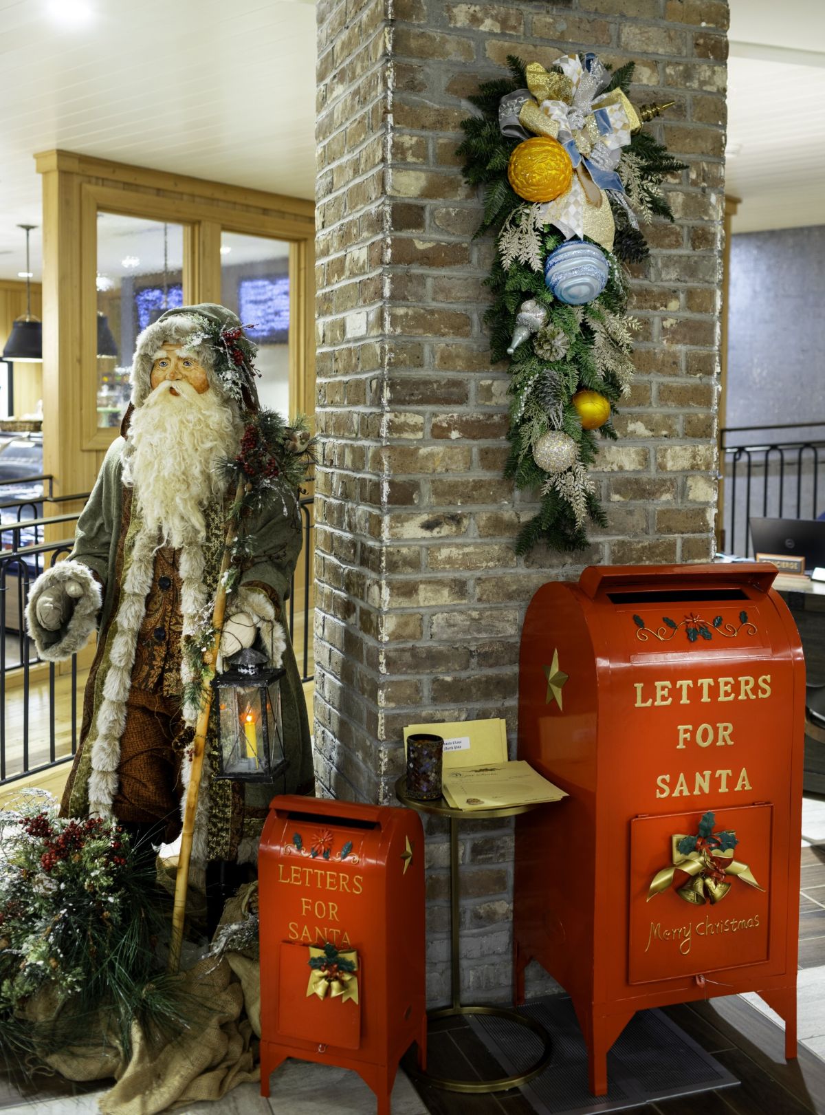 a santa claus standing next to a red mailbox