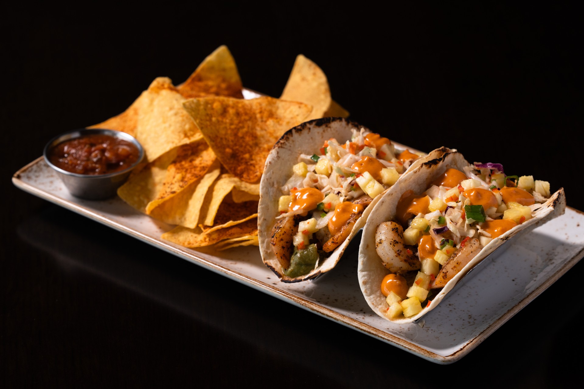 a plate of food with a bowl of salsa and chips