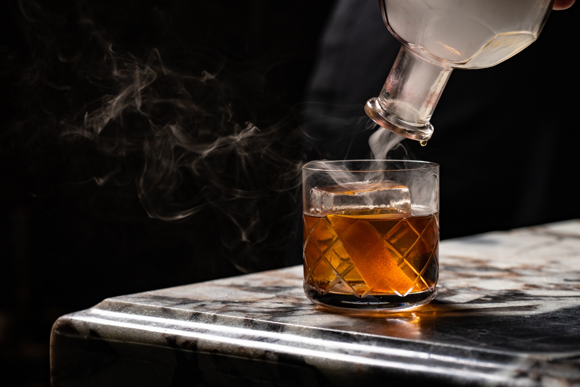 a glass with a drink and smoke coming out of it