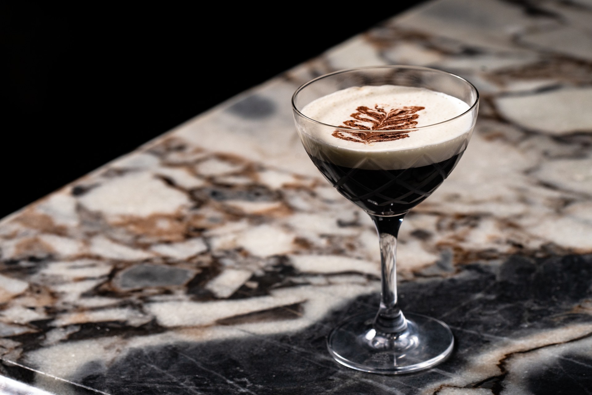 a glass with a drink on a counter