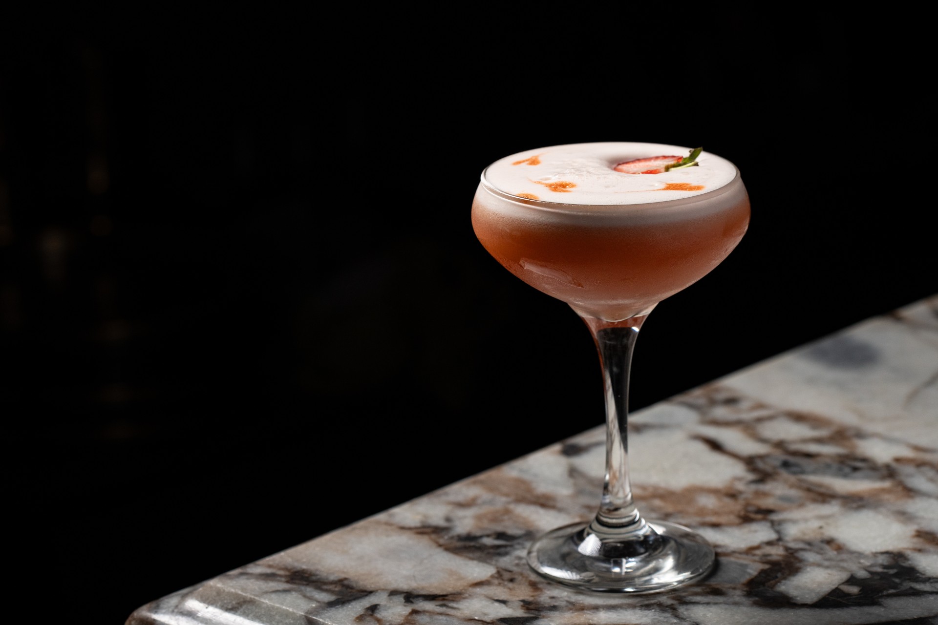 a glass with a drink on a marble surface