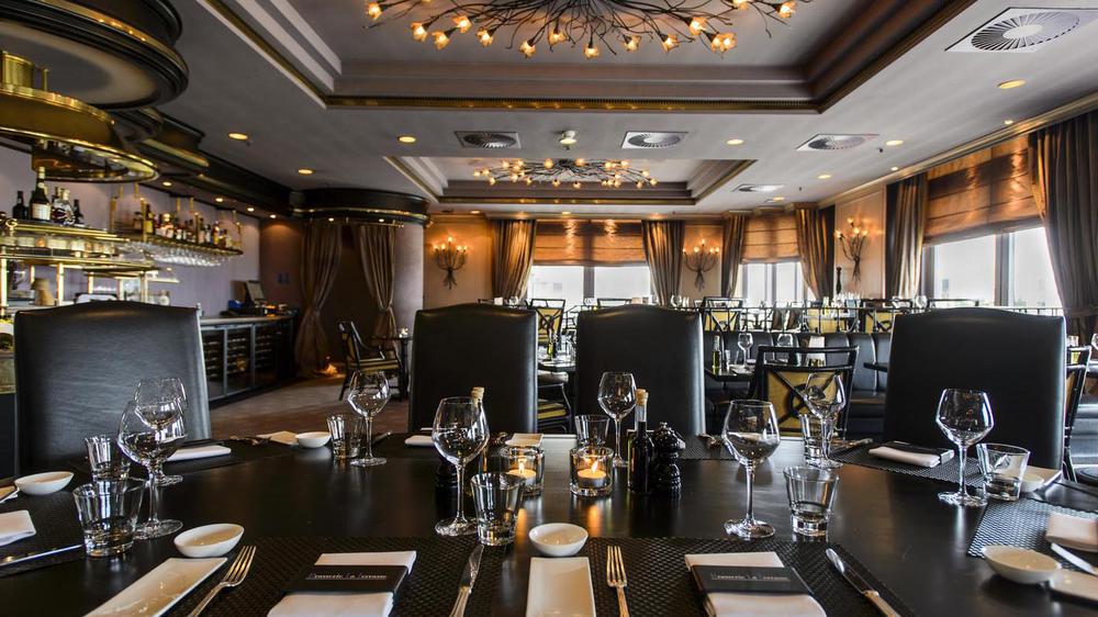 a restaurant with a chandelier and wine glasses