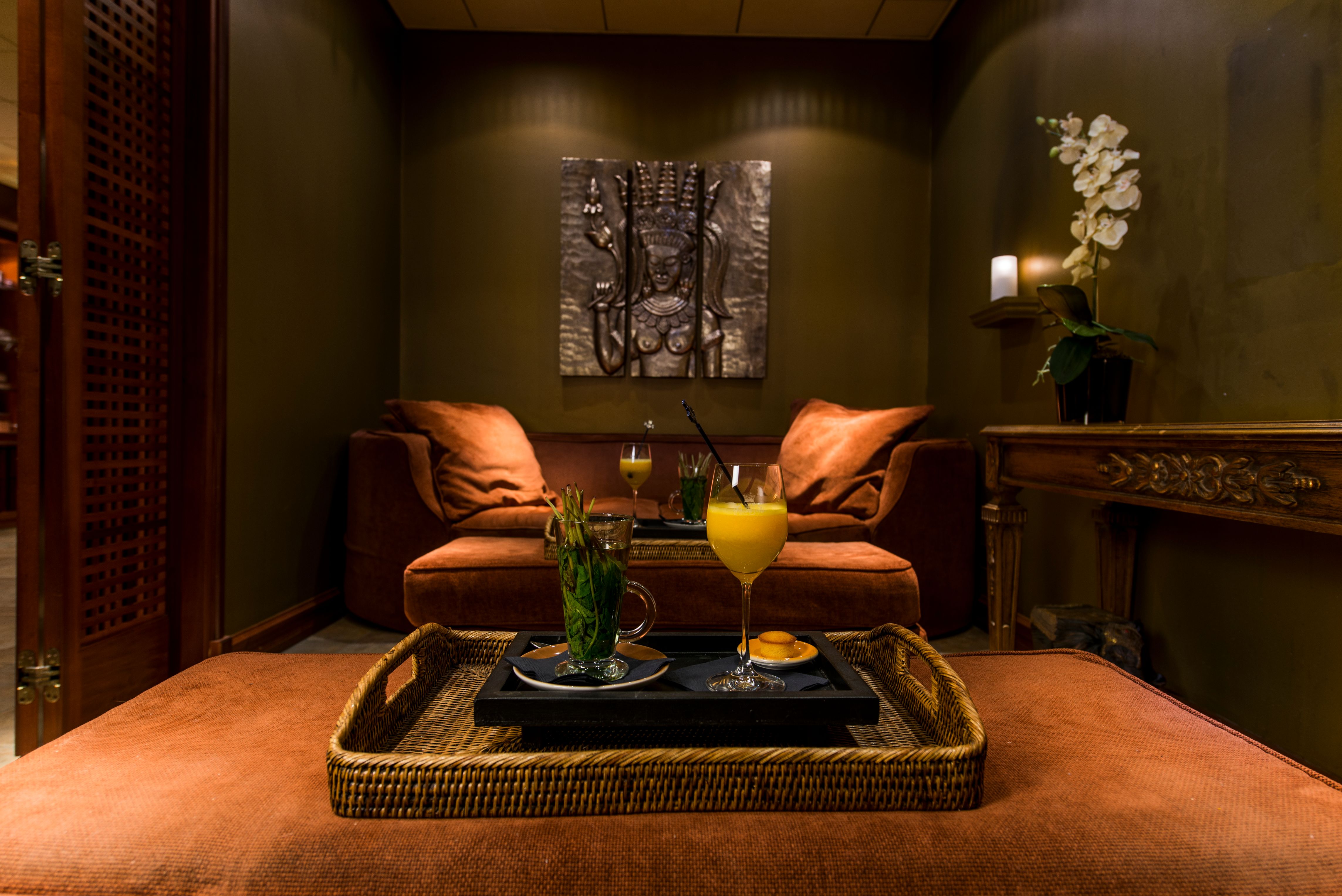 a tray with drinks on it in a room with a couch and a painting on the wall